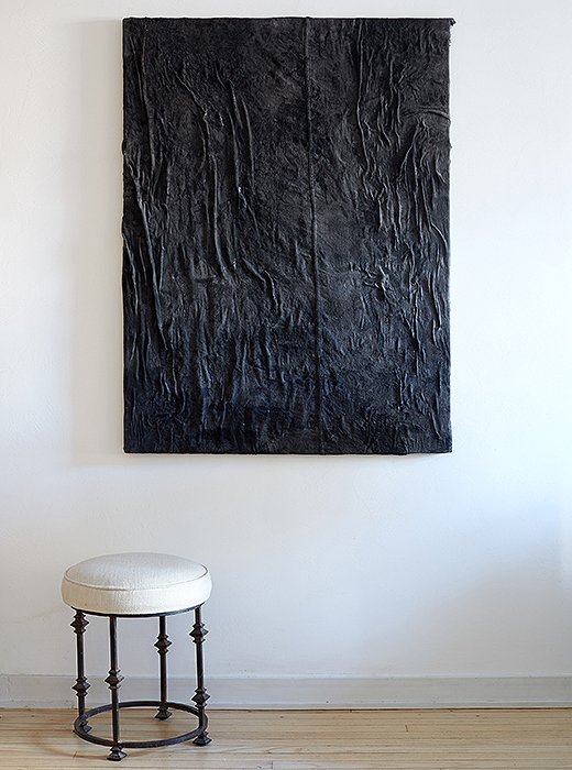 An ultratextured painting by Alex Fideli hangs above a stool of Samuel’s design. Even the backdrop brings dimensionality and rough-and-tumble texture: The floors were bleached and pickled to reflect more light, and the walls were plastered to be a little rough.
